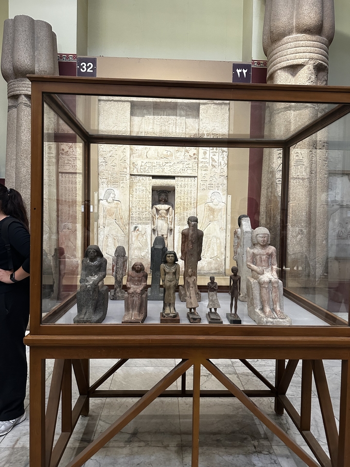 Exposition de musée avec statues antiques et sculptures.