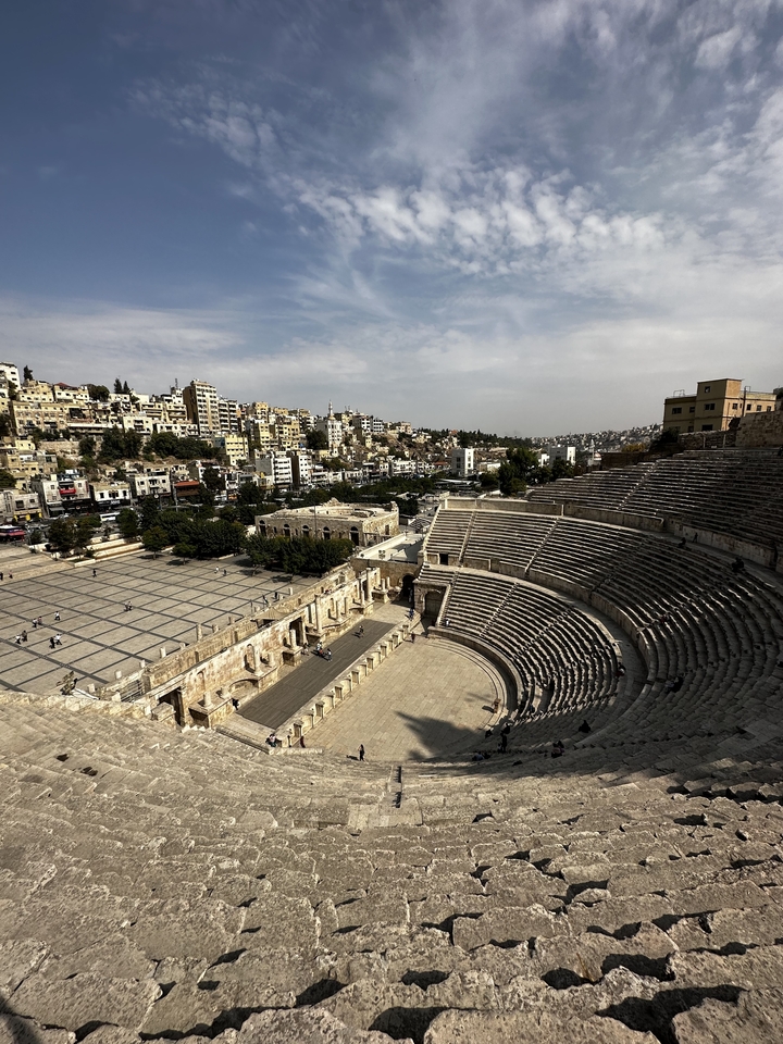Amphithéâtre en plein air avec un paysage urbain en arrière-plan.