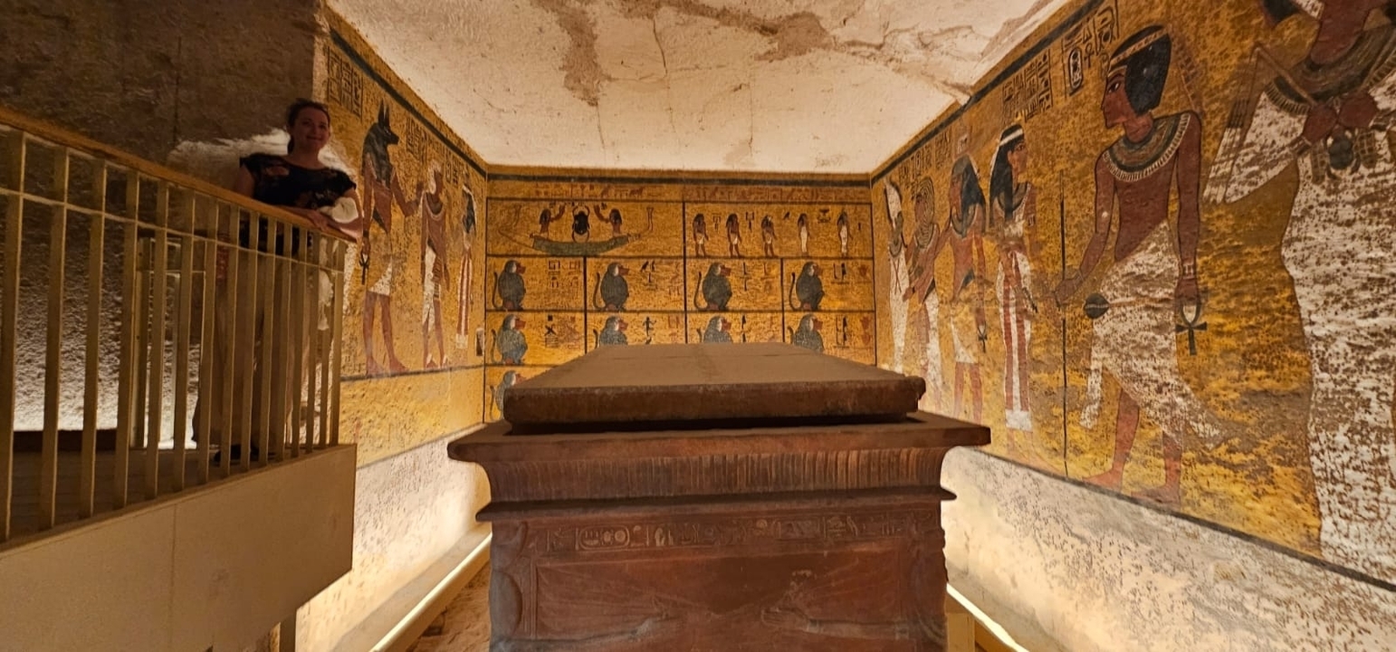 Intérieur d'un tombeau antique avec des peintures murales détaillées.