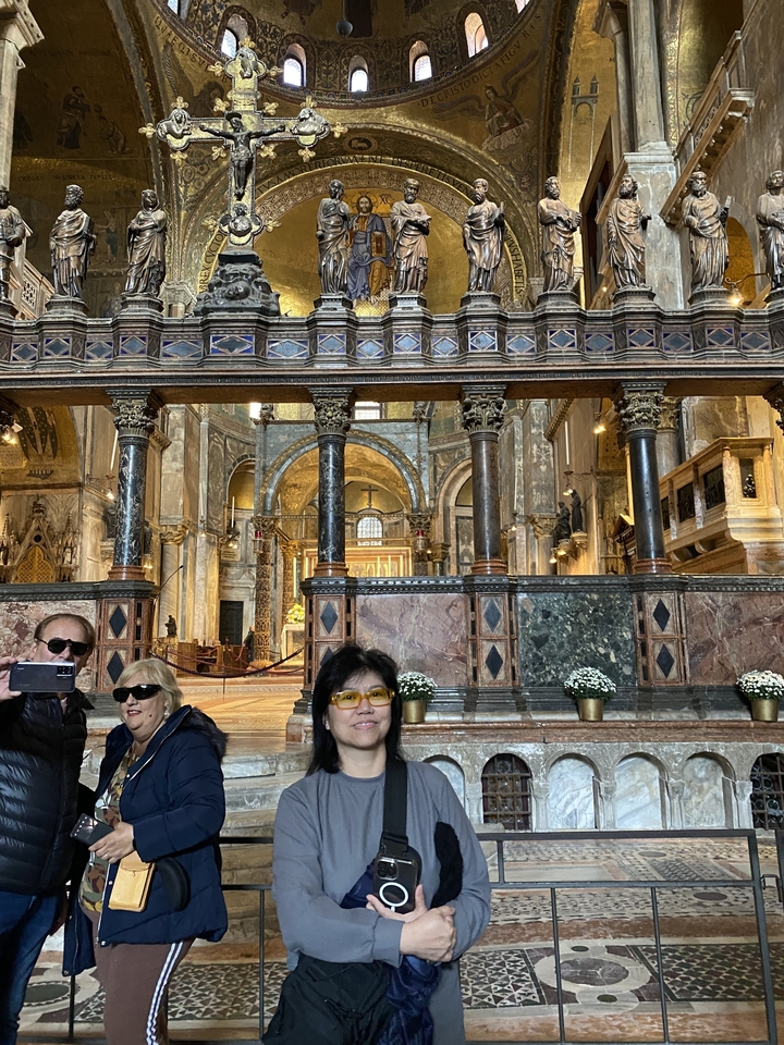 Des touristes à l'intérieur d'une église historique aux intérieurs ornés.