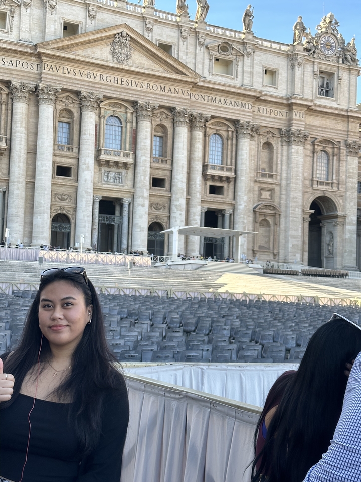 Une femme debout devant un bâtiment historique célèbre.