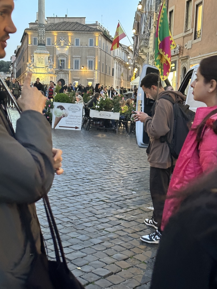 Des gens debout sur une place de la ville.