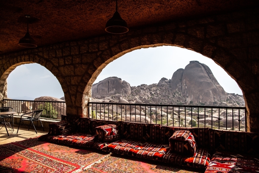 Une vue depuis une terrasse avec des sièges traditionnels donnant sur des formations rocheuses.