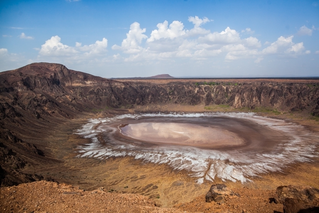 Un cratère avec des couches de sédiments multicolores.