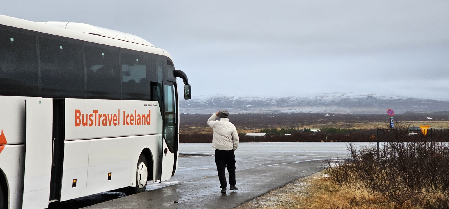 Tourist by a bus in a snowy landscape.