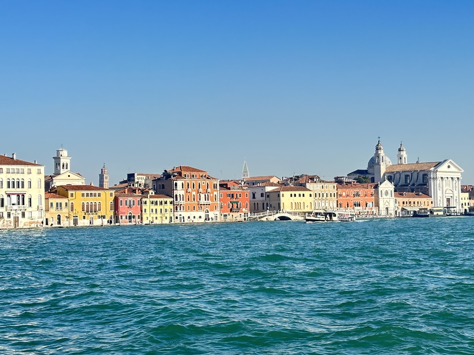 Bâtiments colorés au bord de l'eau avec une église à Venise.