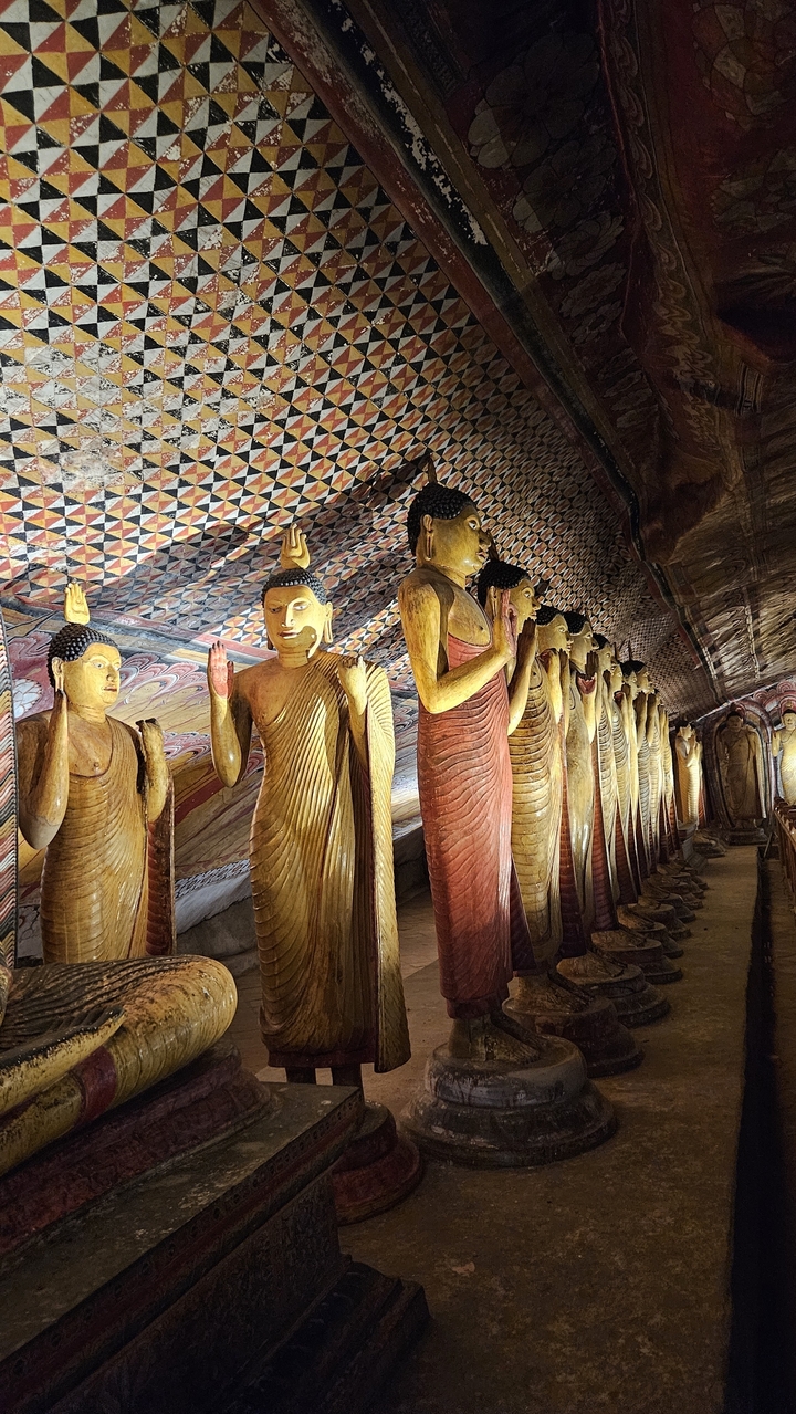 Rangée de statues de Bouddha à l'intérieur d'un temple rupestre.