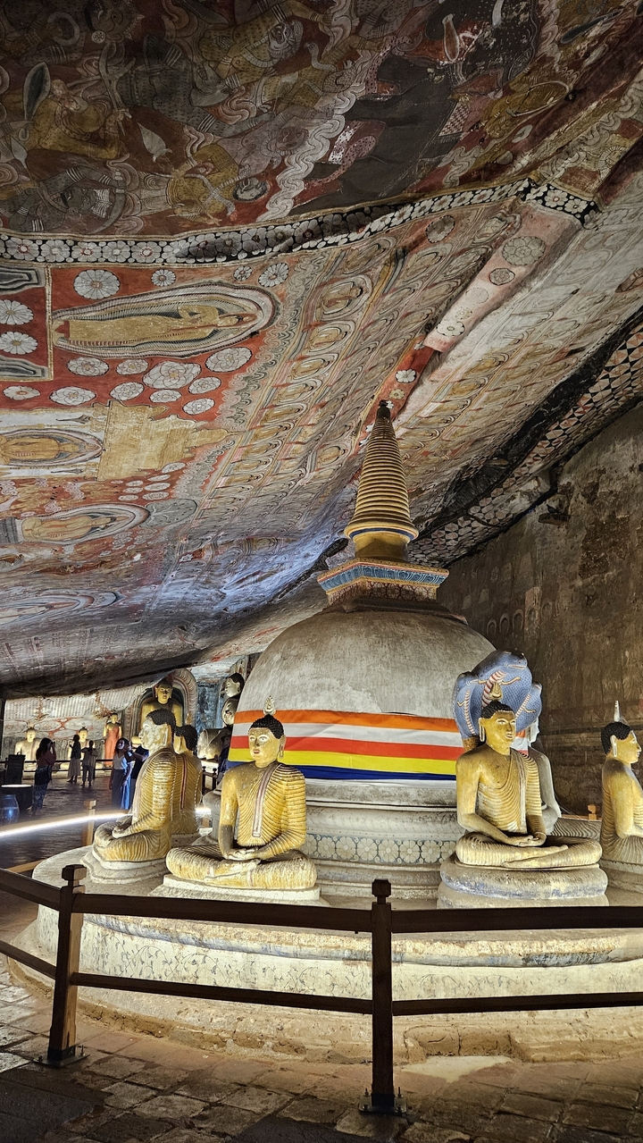 Intérieur d'un temple rupestre avec un stupa et des fresques.