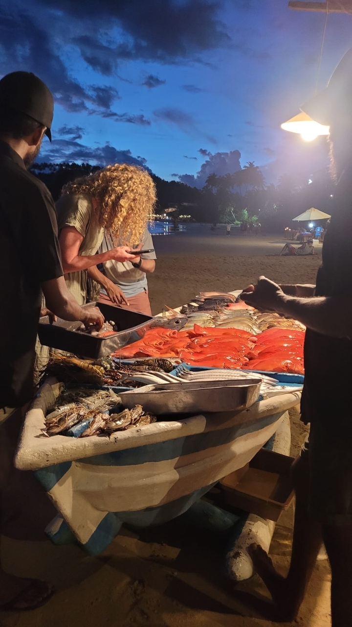 Marché en bord de mer vendant des fruits de mer frais la nuit.