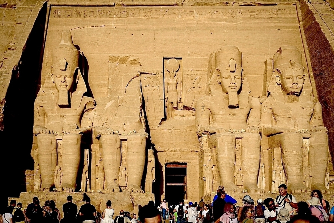 Abu Simbel avec de grandes statues assises et des touristes.