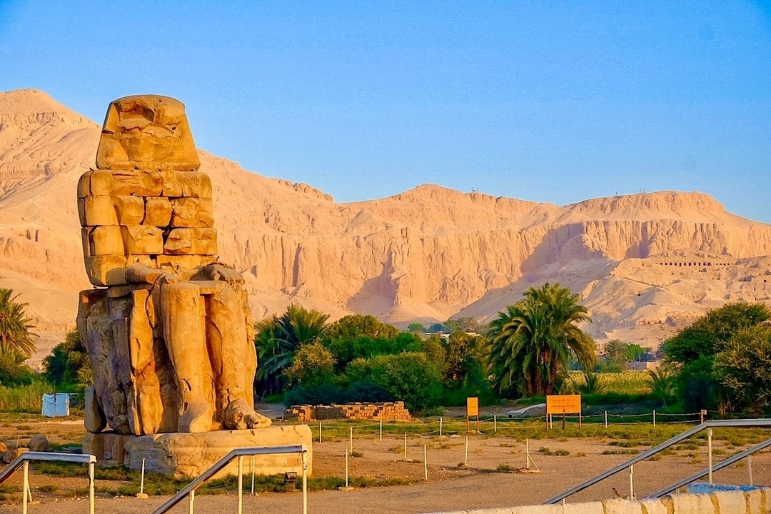 Les Colosses de Memnon à Louxor avec un arrière-plan pittoresque.