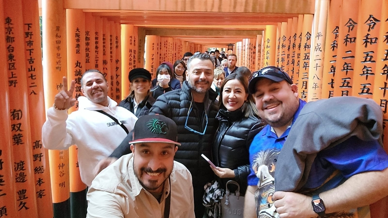 Groupe de personnes posant devant un torii avec des inscriptions.