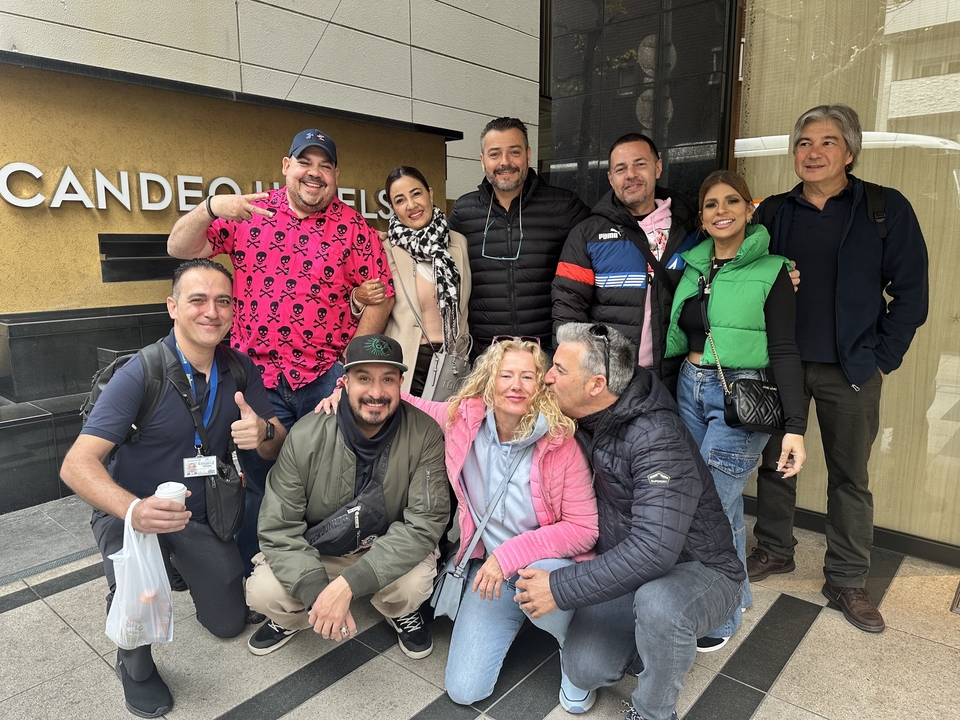 Groupe de personnes posant à l'extérieur d'un bâtiment.
