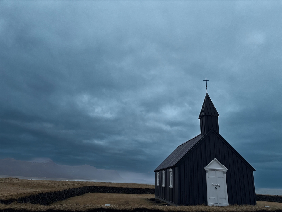 Vue dramatique d'une église sombre sur un ciel nuageux.