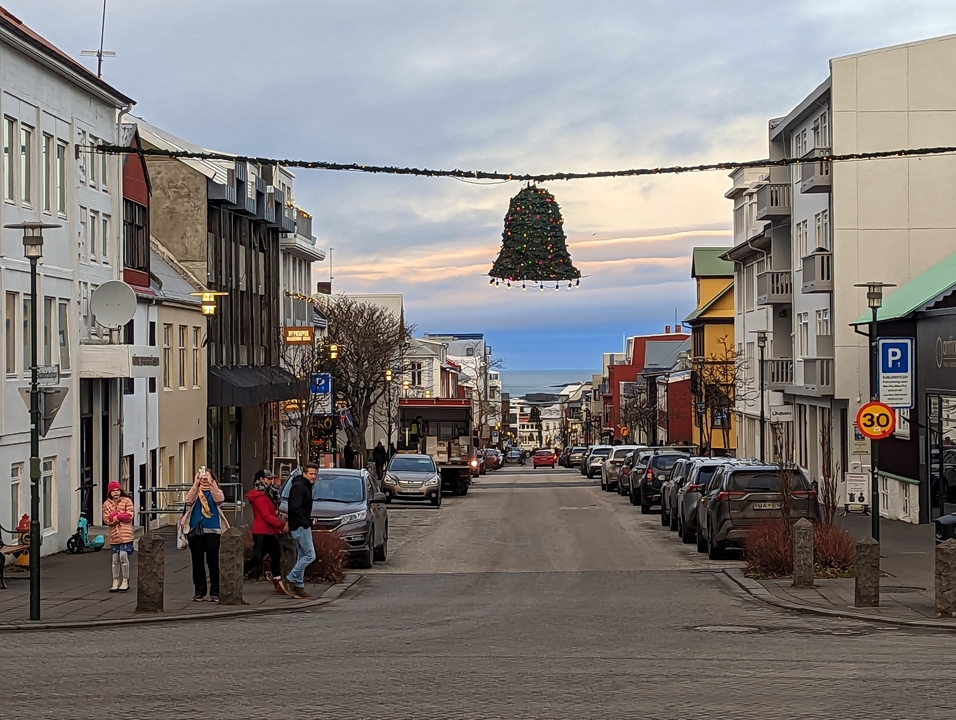 Scène de rue à Reykjavik avec décoration de Noël et vue sur l'océan.
