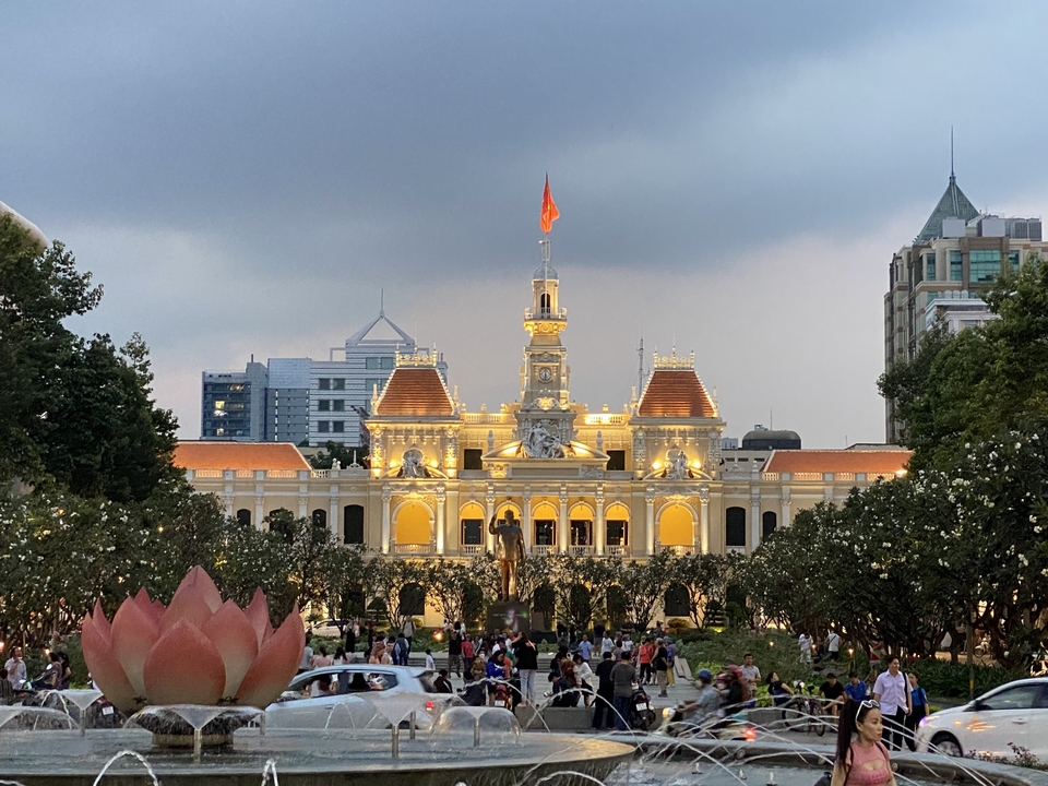 Bâtiment historique illuminé avec des gens autour.