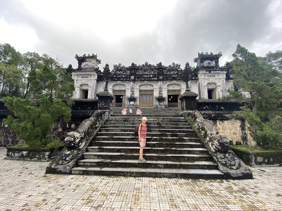 Femme sur les marches d'un tombeau orné et imposant.