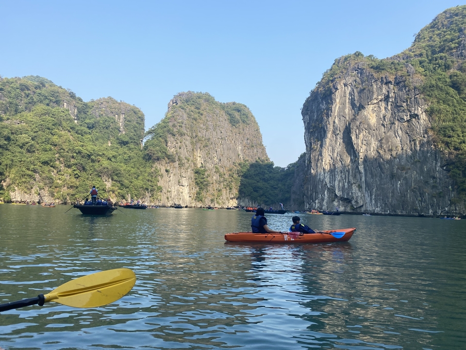 Des gens faisant du kayak dans une baie entourée de falaises.
