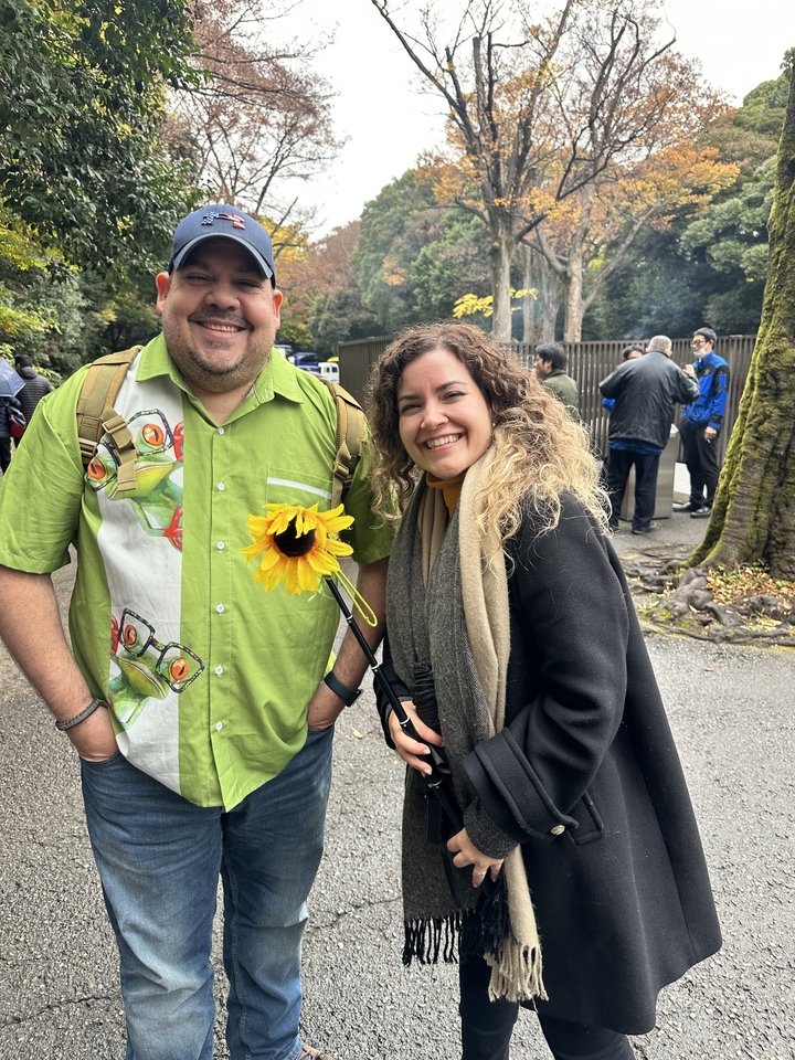 Deux personnes souriantes, l'une tenant un tournesol.