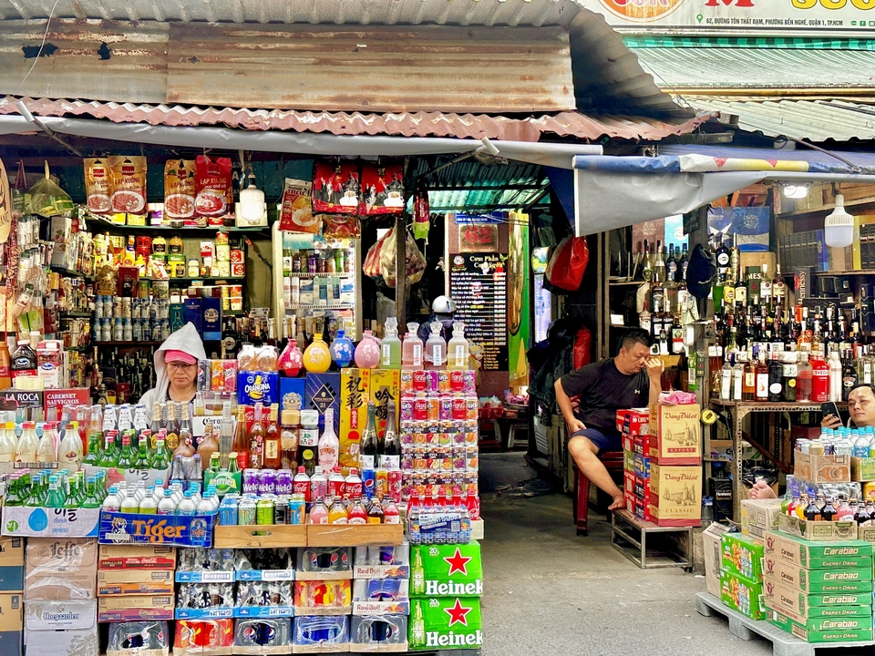 Étal de marché animé avec divers produits et des gens.