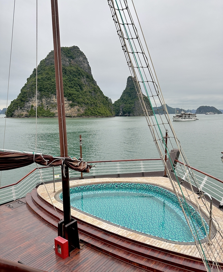 Bateau de croisière sur la baie d'Halong avec des îles de calcaire.