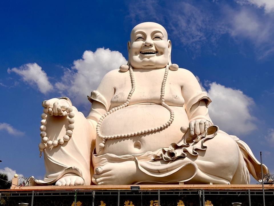 Grande statue blanche de Bouddha avec ciel bleu.