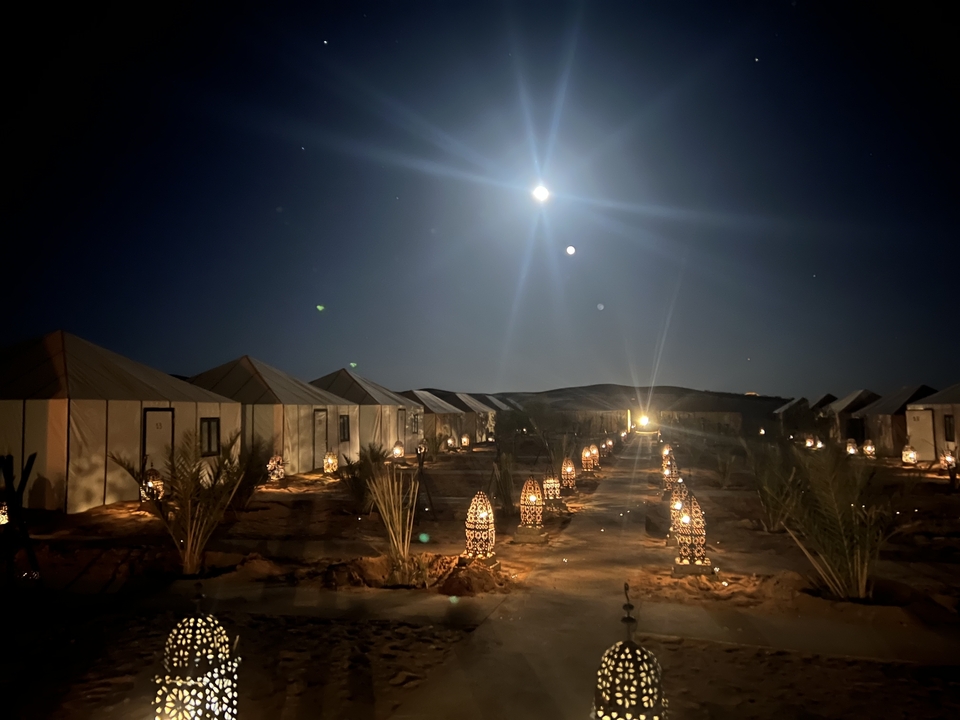 Campement du désert éclairé par des lanternes sous le clair de lune.