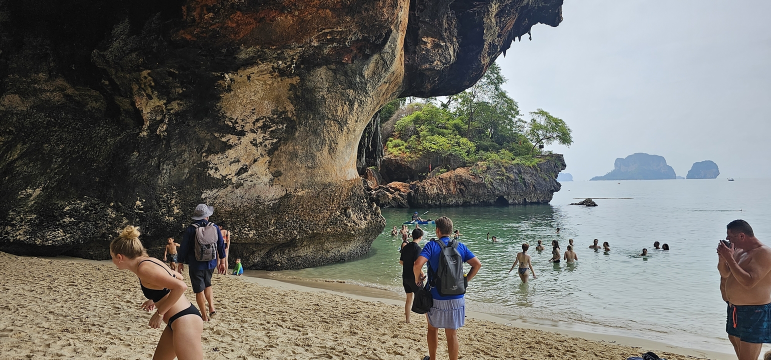 Des touristes profitant d'une plage avec de magnifiques falaises en arrière-plan.