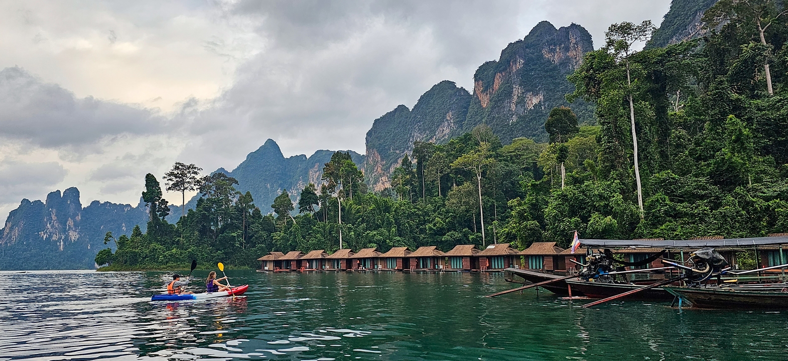 Des kayakistes sur un lac serein avec des montagnes luxuriantes.