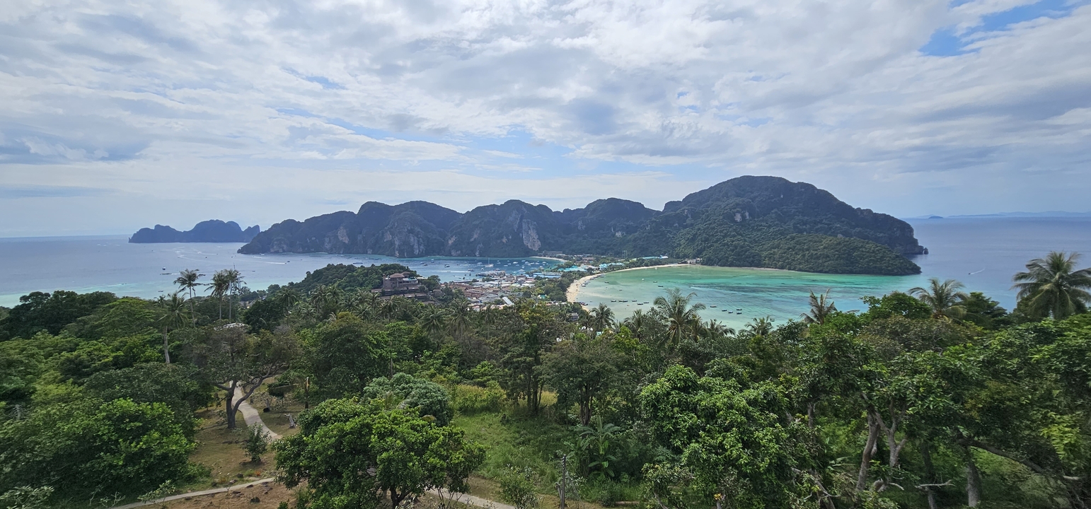 Vue aérienne d'une baie avec une végétation luxuriante et des montagnes.