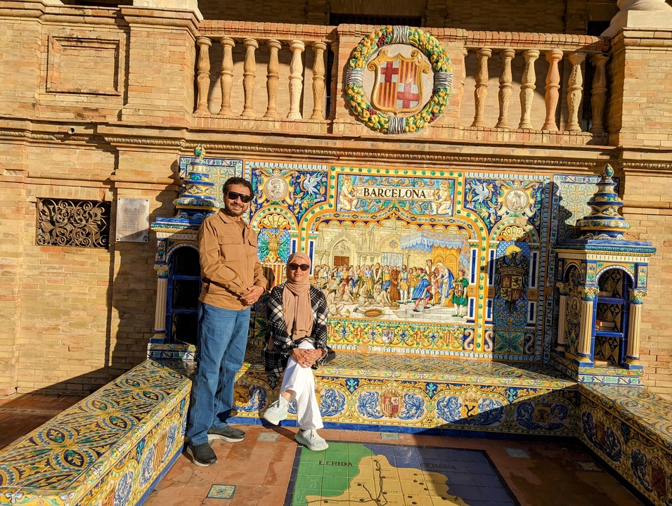 Touristes posant devant une fresque carrelée dans une cour