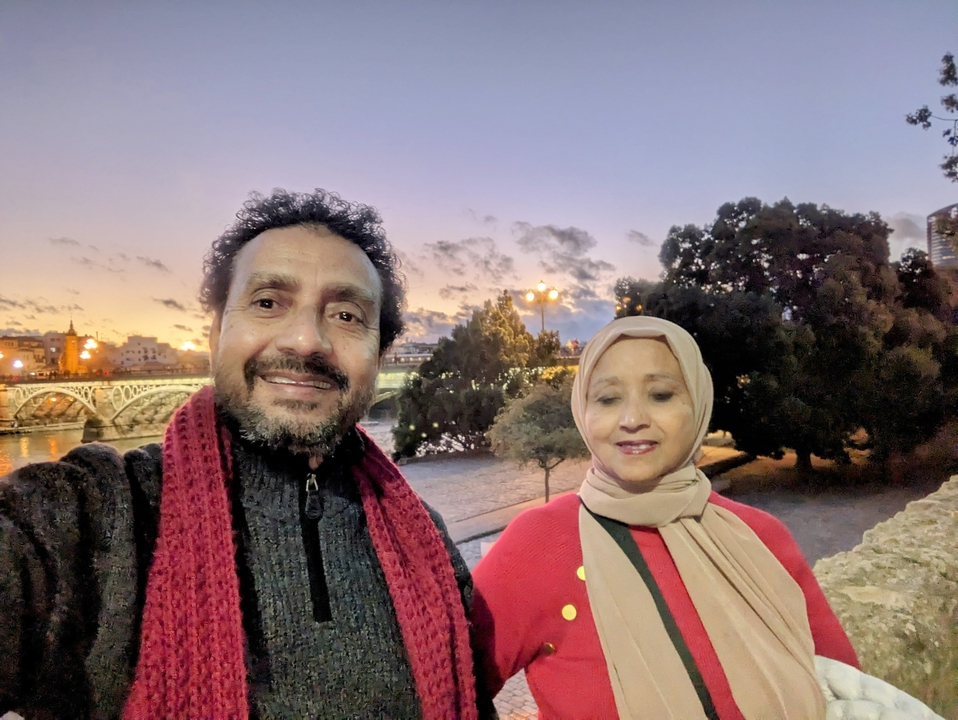 Couple prenant un selfie près d'un pont au coucher du soleil