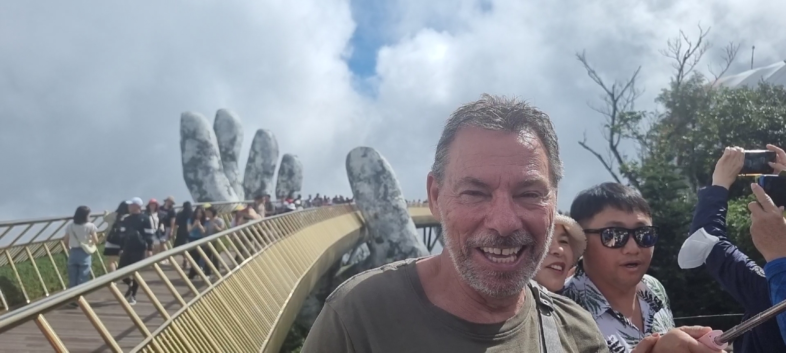Touriste posant sur le Pont Doré avec une foule
