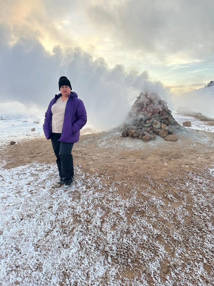Personne debout près d'une bouche de vapeur dans un paysage enneigé.