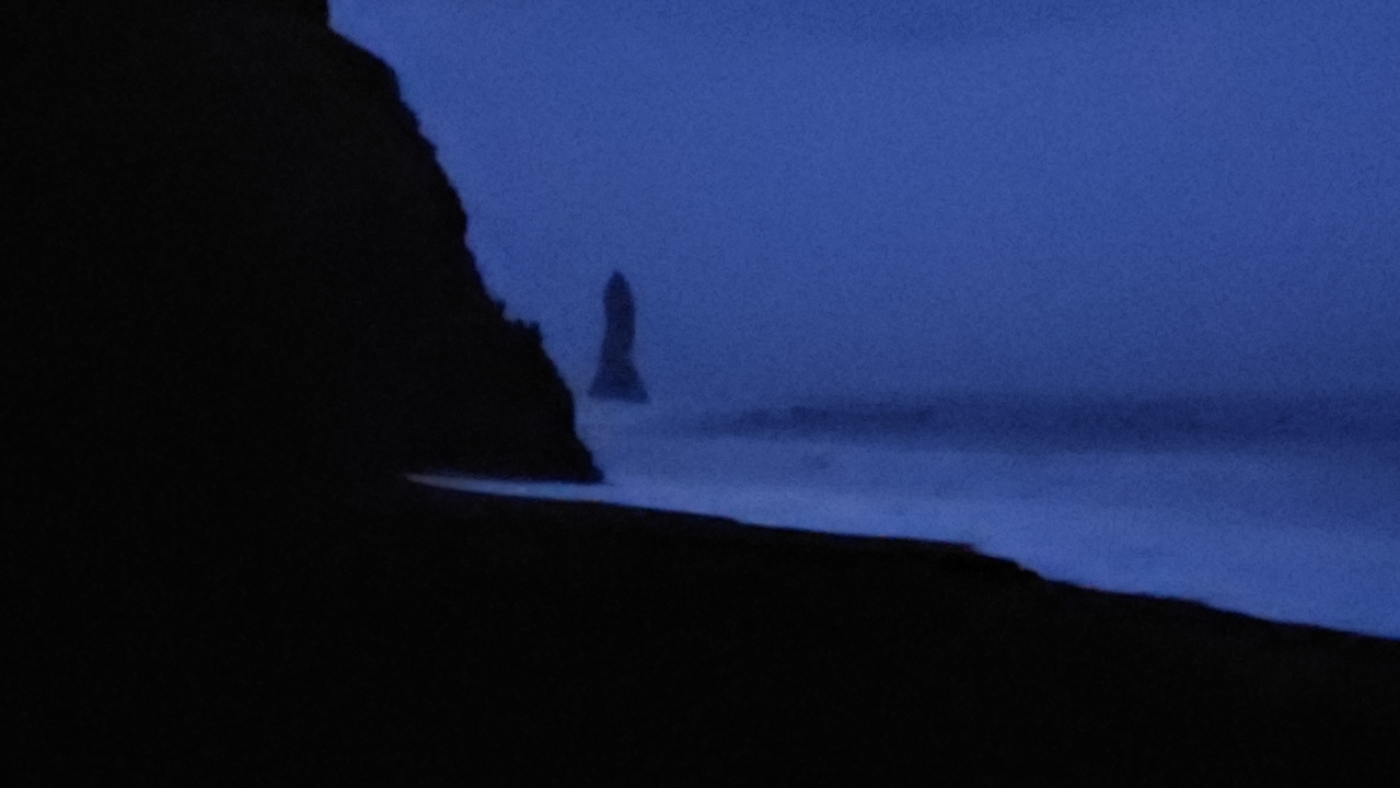 Silhouette sombre d'une montagne rocheuse près de la mer.
