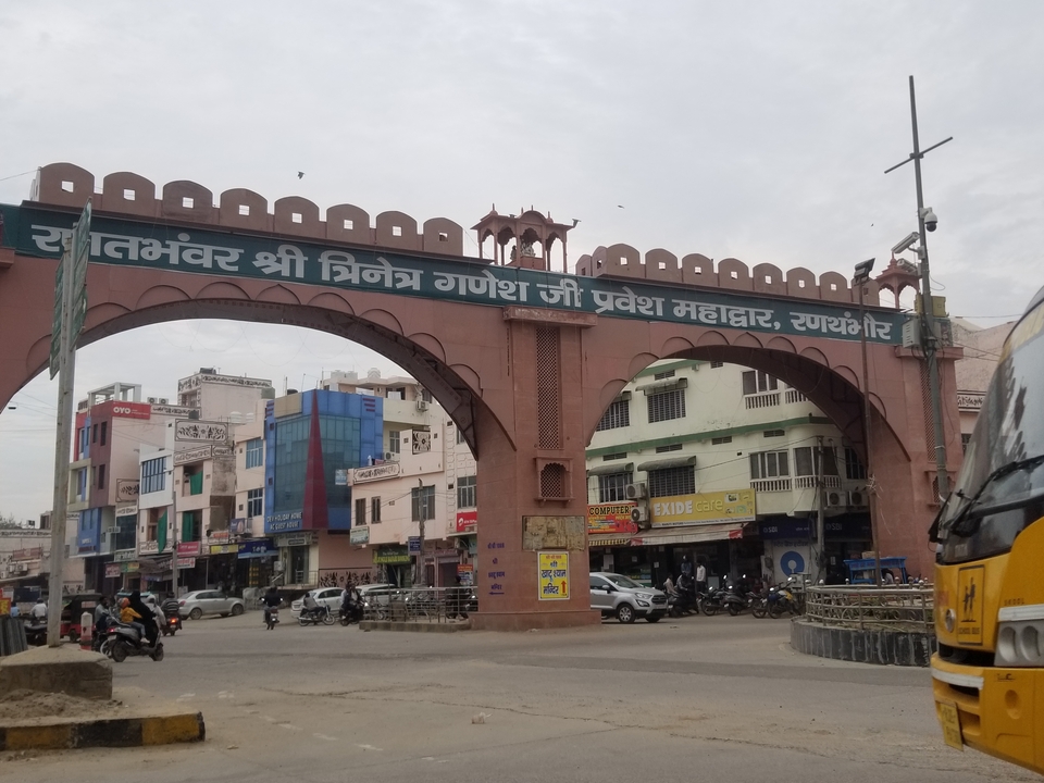 Entrée voûtée vers une zone urbaine animée.