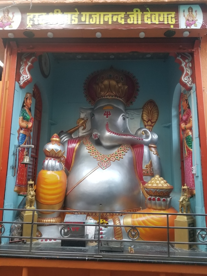 Une grande statue d'une divinité éléphant à l'intérieur d'un espace de temple.