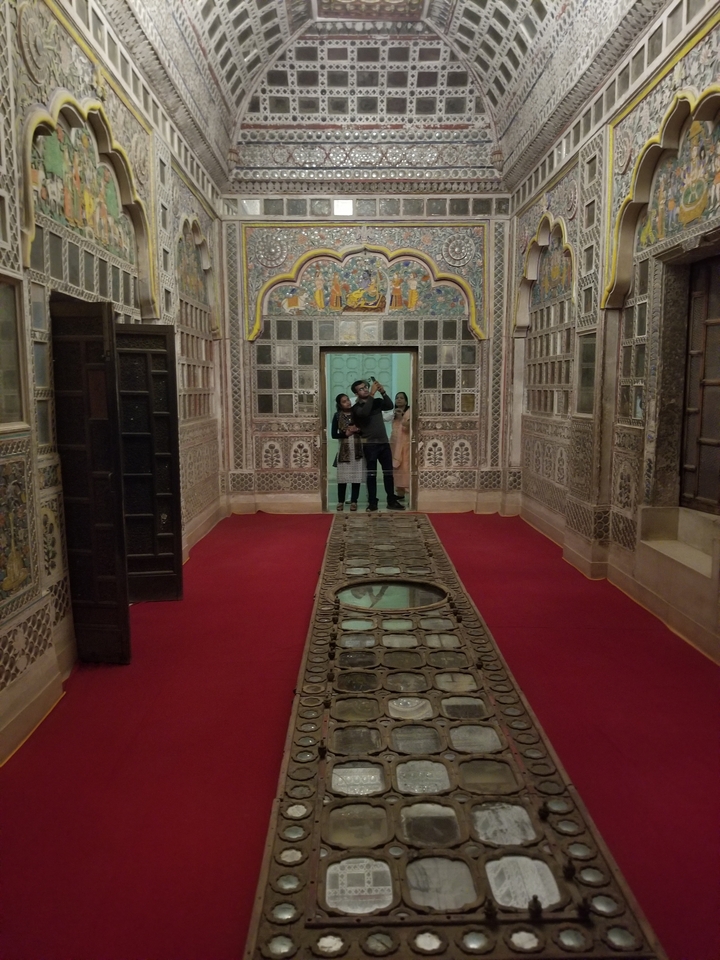 Trois personnes explorant l'intérieur d'un bâtiment décoratif.
