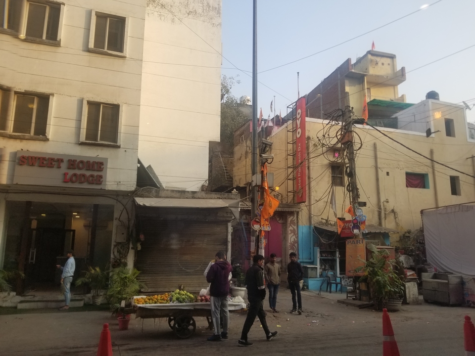 Scène de rue urbaine avec des bâtiments et des gens qui passent.