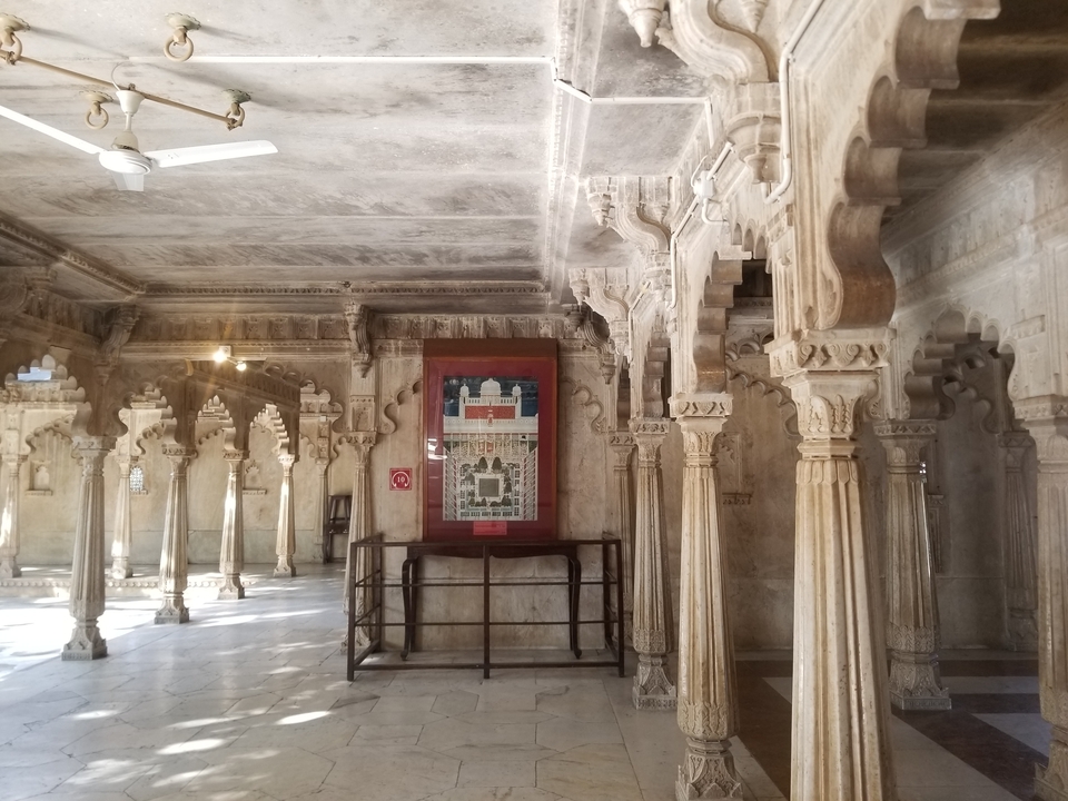 Intérieur avec colonnes décoratives et une carte au mur.
