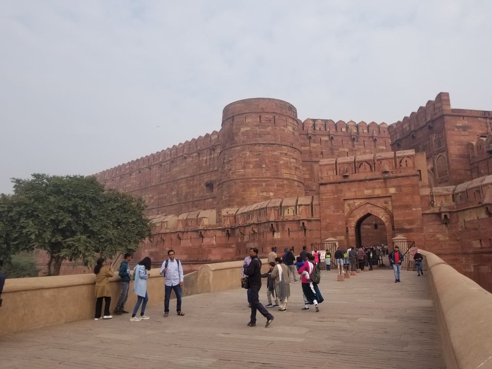 Des visiteurs entrant dans un grand fort rouge.