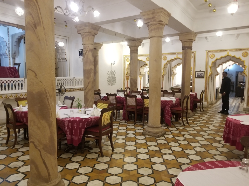 Salle à manger traditionnelle avec décor orné et tables de repas.