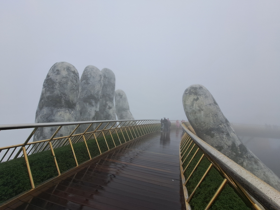 Une scène brumeuse du Golden Bridge avec des structures de mains géantes.