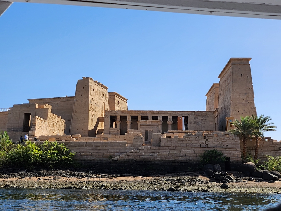 Ruines d'un temple ancien avec de grandes structures en pierre entourées de plantes.