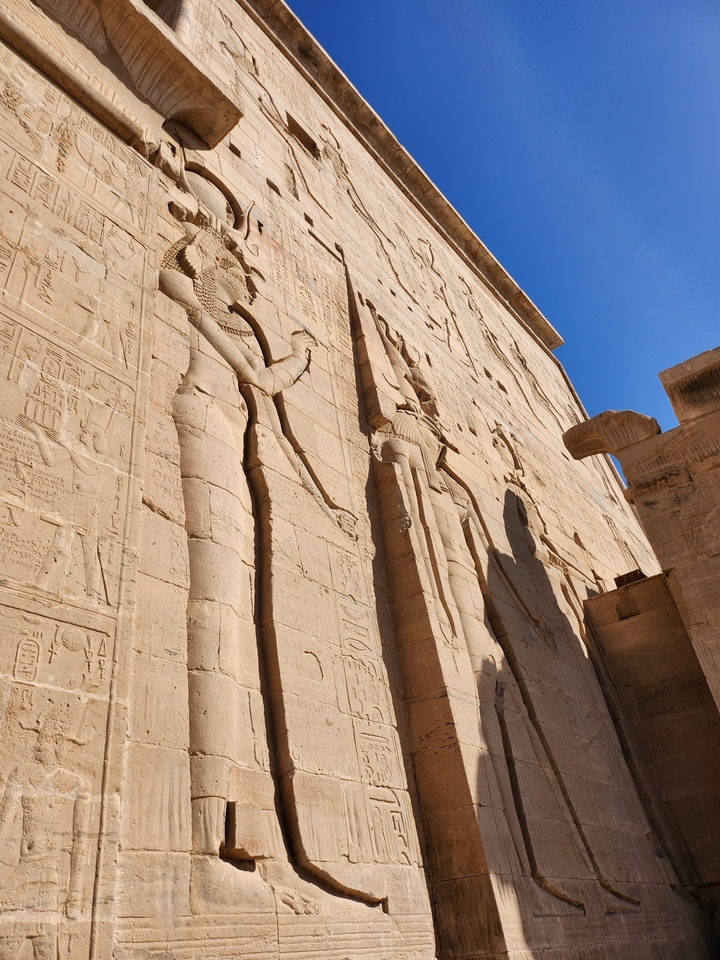 Hiéroglyphes égyptiens gravés sur un mur de pierre.