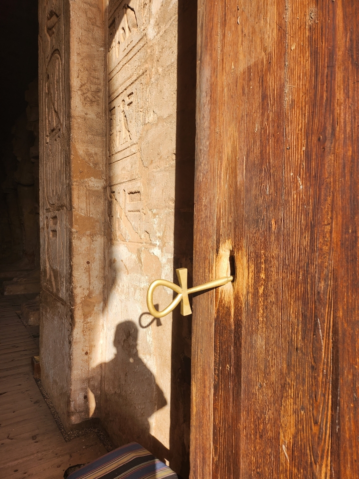 Porte en bois avec un symbole ankh sculpté dessus.