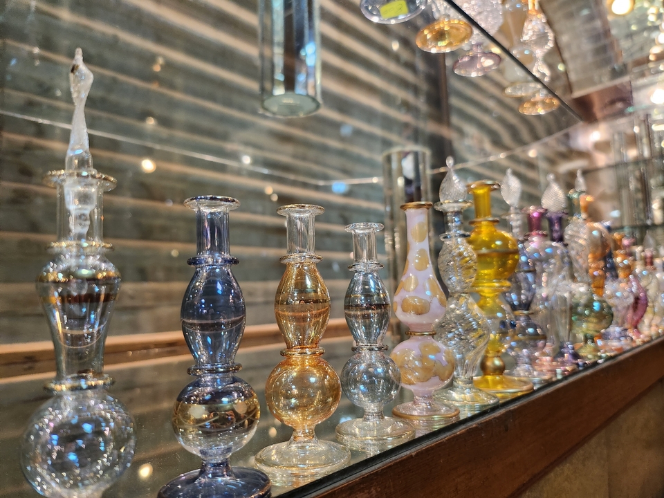 Des bouteilles en verre colorées exposées dans une boutique.