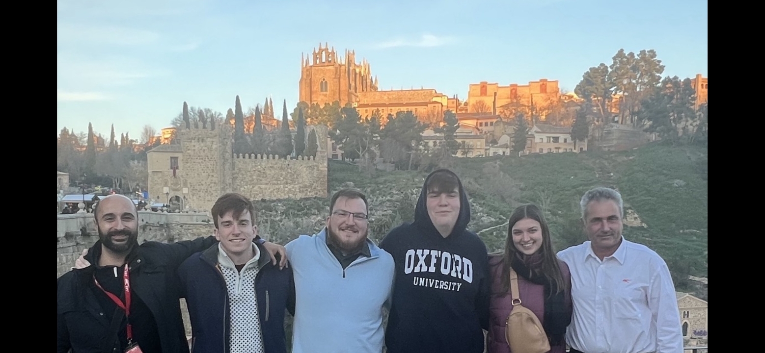 Groupe de personnes avec un bâtiment historique en arrière-plan.