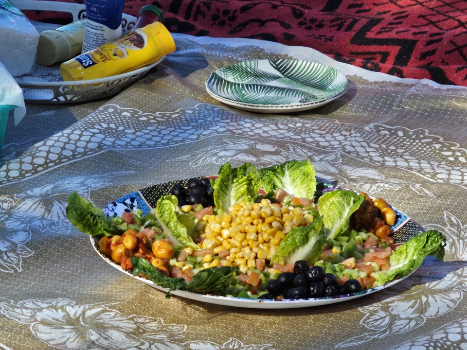 Dressage de table d'une salade fraîche avec du maïs et des légumes.