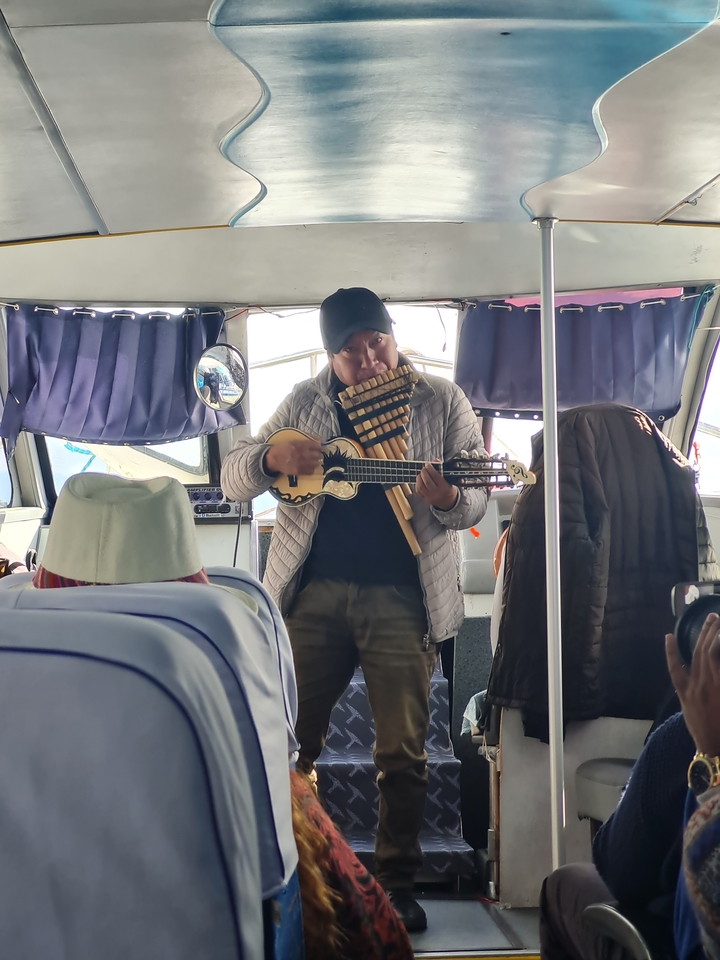 Homme jouant des instruments de musique traditionnels sur un bateau.